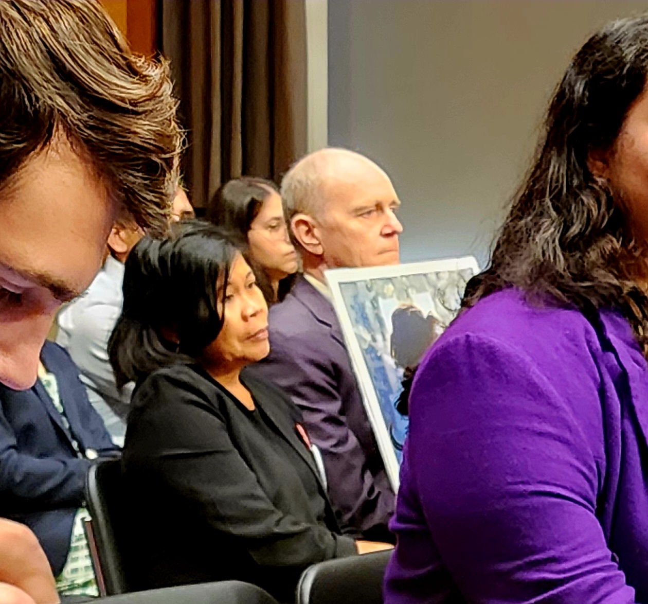 A couple in the center holding a photo.