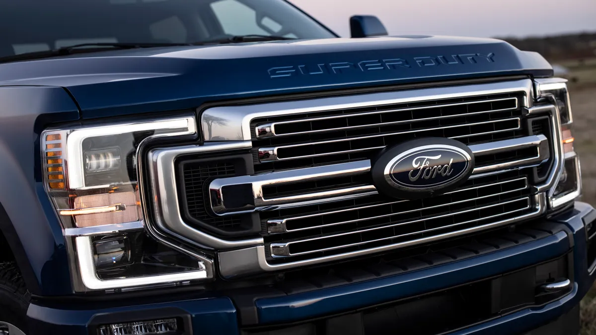 The front grill showing a Ford badge on a dark blue 2022 Ford F- Series Super Duty pickup truck.