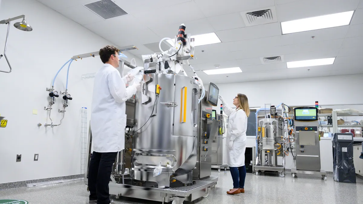 Employees of biotechnology company UniQure work in a laboratory.