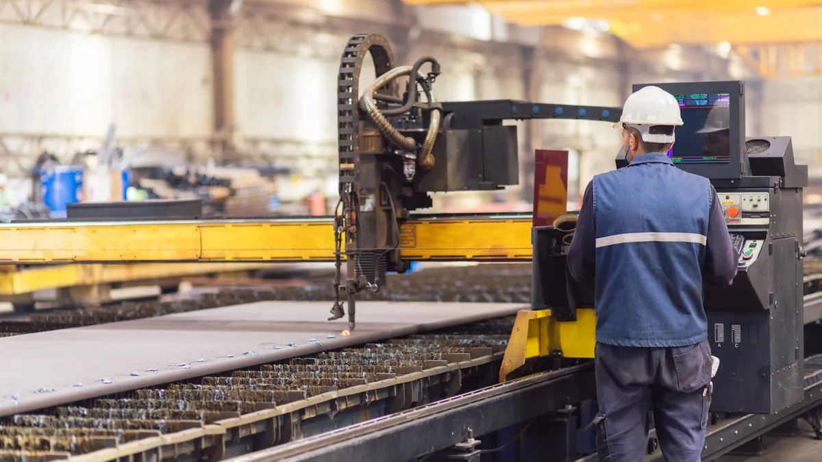 Steel worker on CNC plasma cutter machine