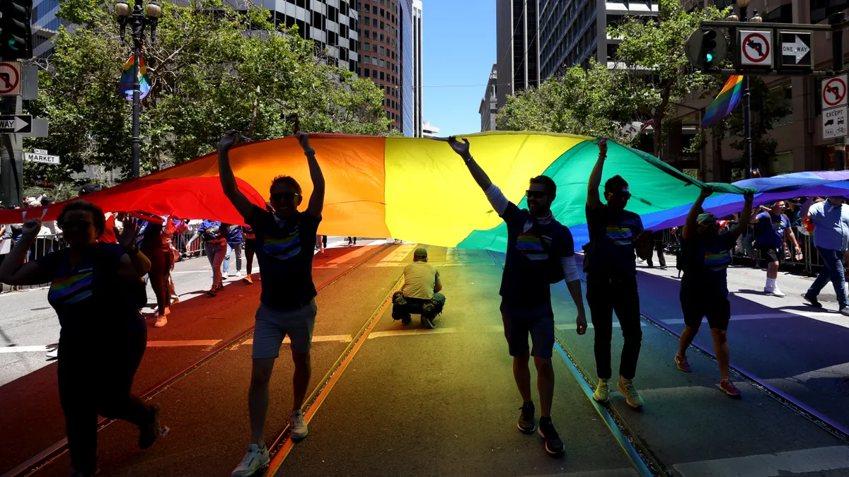 Light through the Pride flag turns the street many colors.