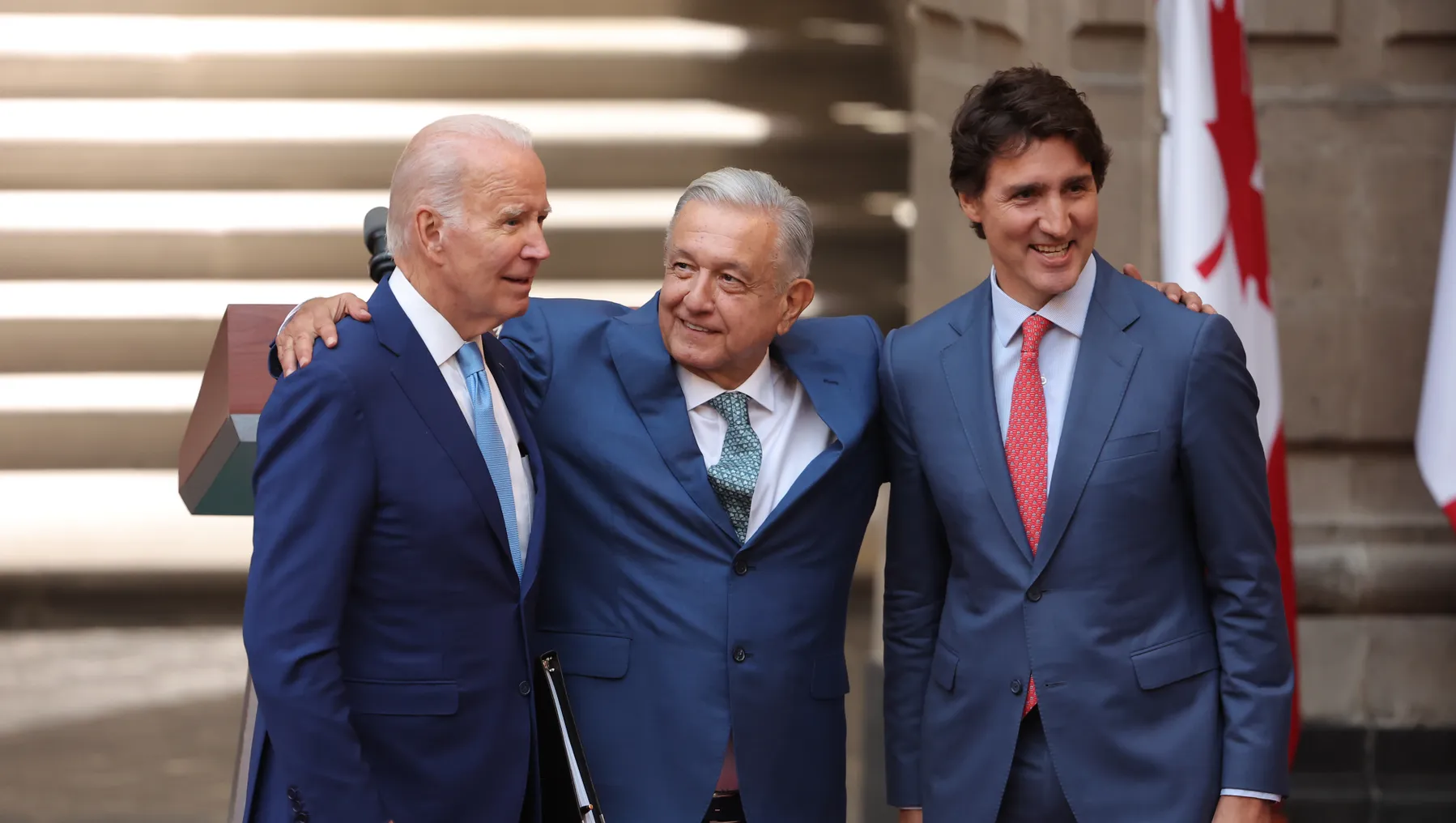 U.S. President Joe Biden, President of Mexico Andres Manuel Lopez Obrador and Prime Minister of Canada Justin Trudeau hug each other.