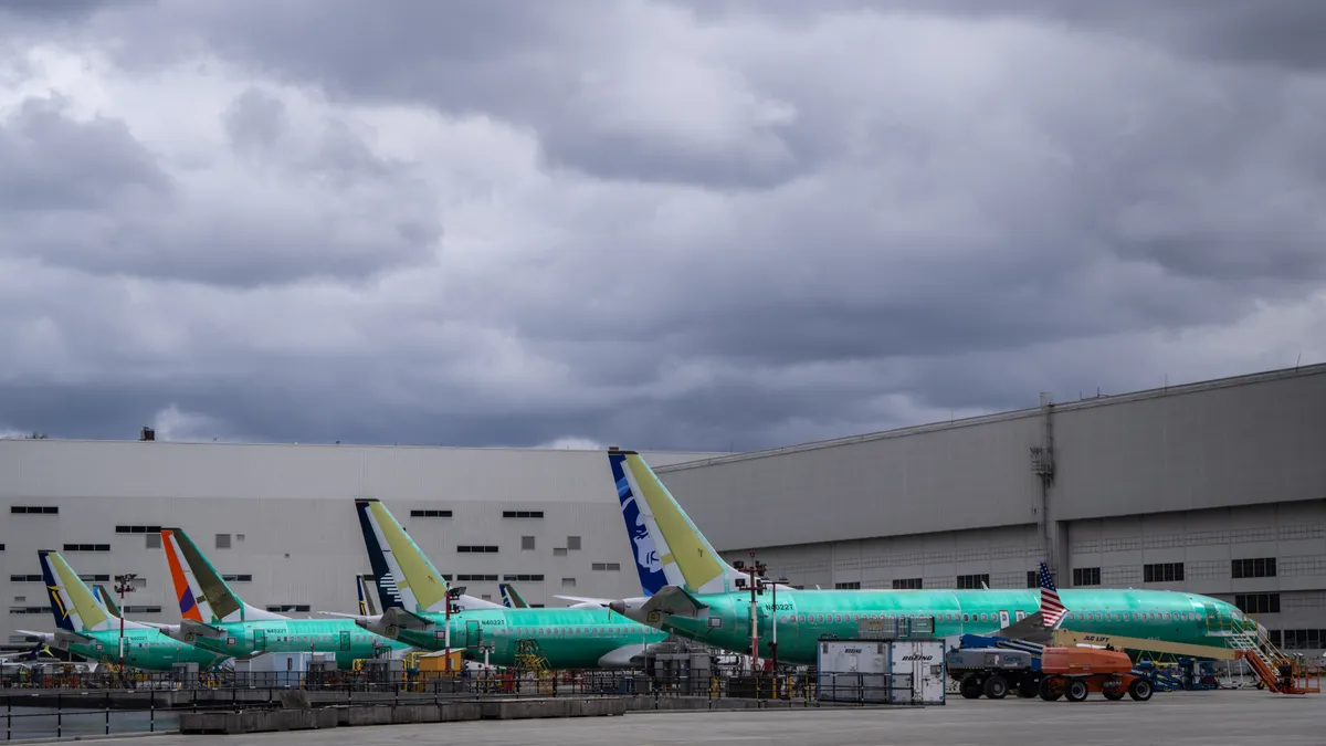 Four green planes align on the ground.