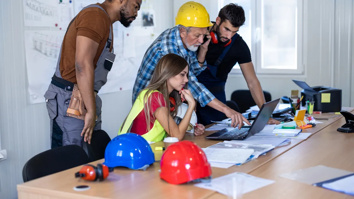 Multi-ethnic group of construction workers working in an office space.