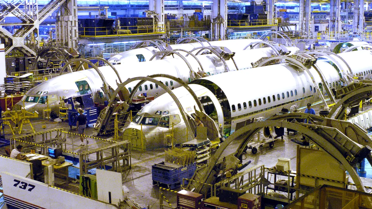 Three fuselages being assembled inside a factory.