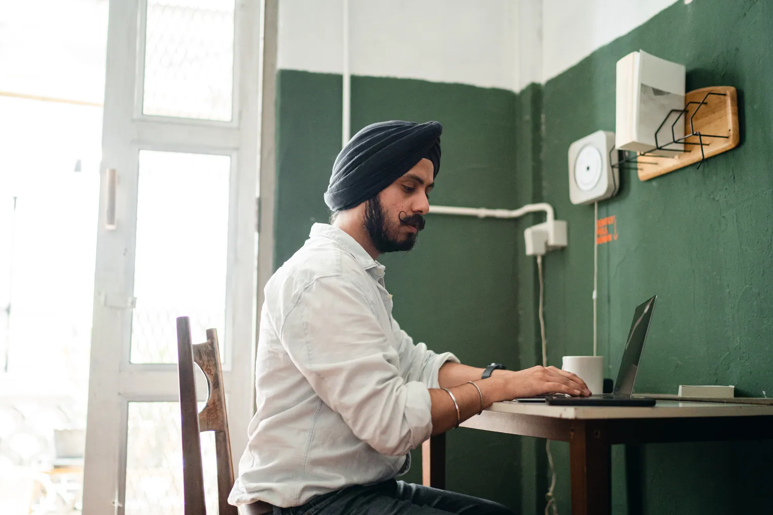 An Indian man works from home on a laptop