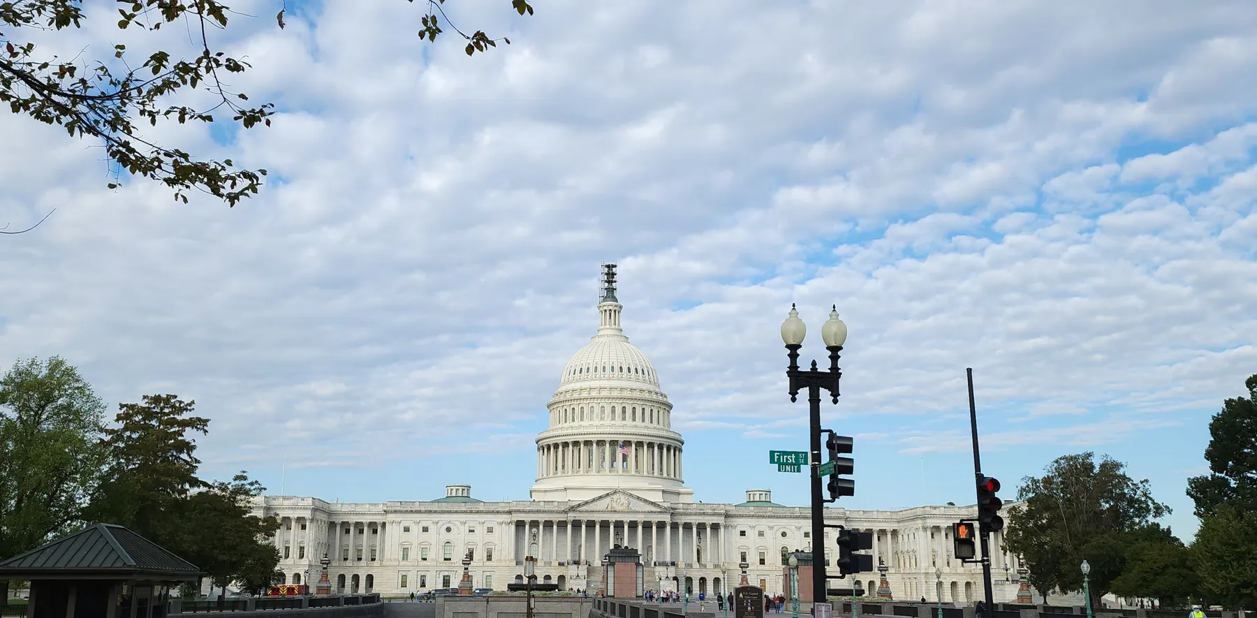 The front of the U.S. Capital with white clouds and blue sky.