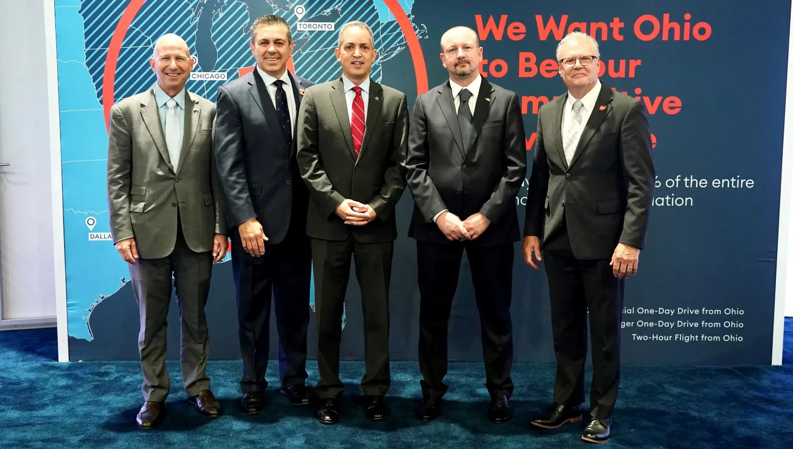 Five people in business suits standing next to each other.